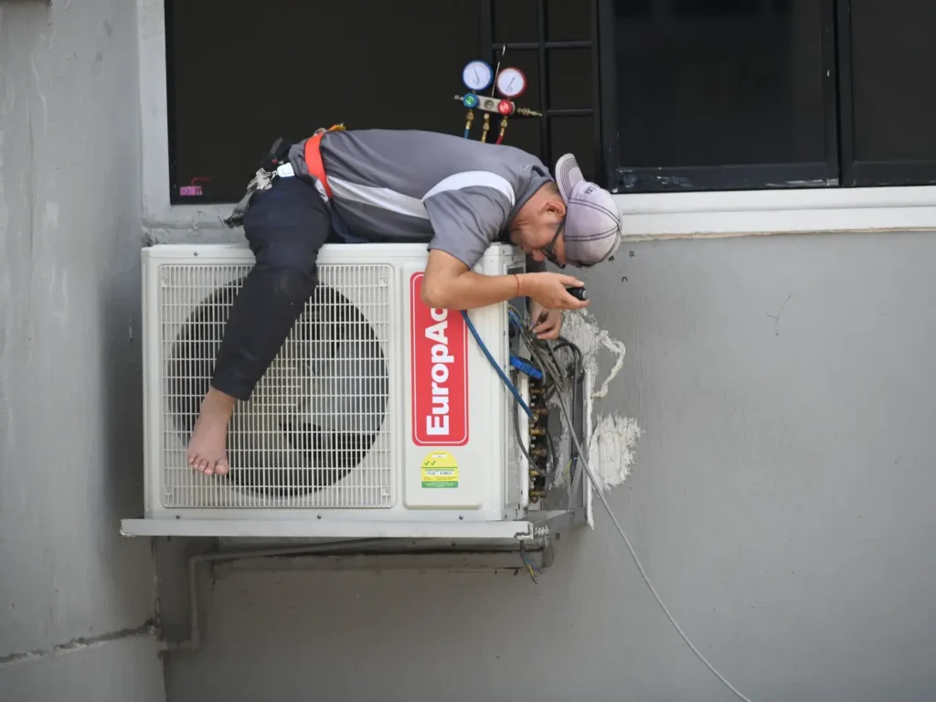 Technician servicing the outdoor unit of a split air conditioner