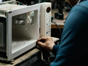 Technician repairing a microwave oven