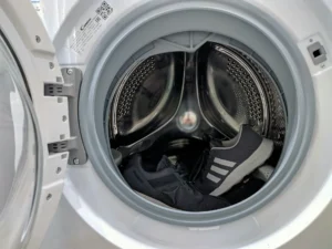 Front-load washing machine with the door open, drum visible