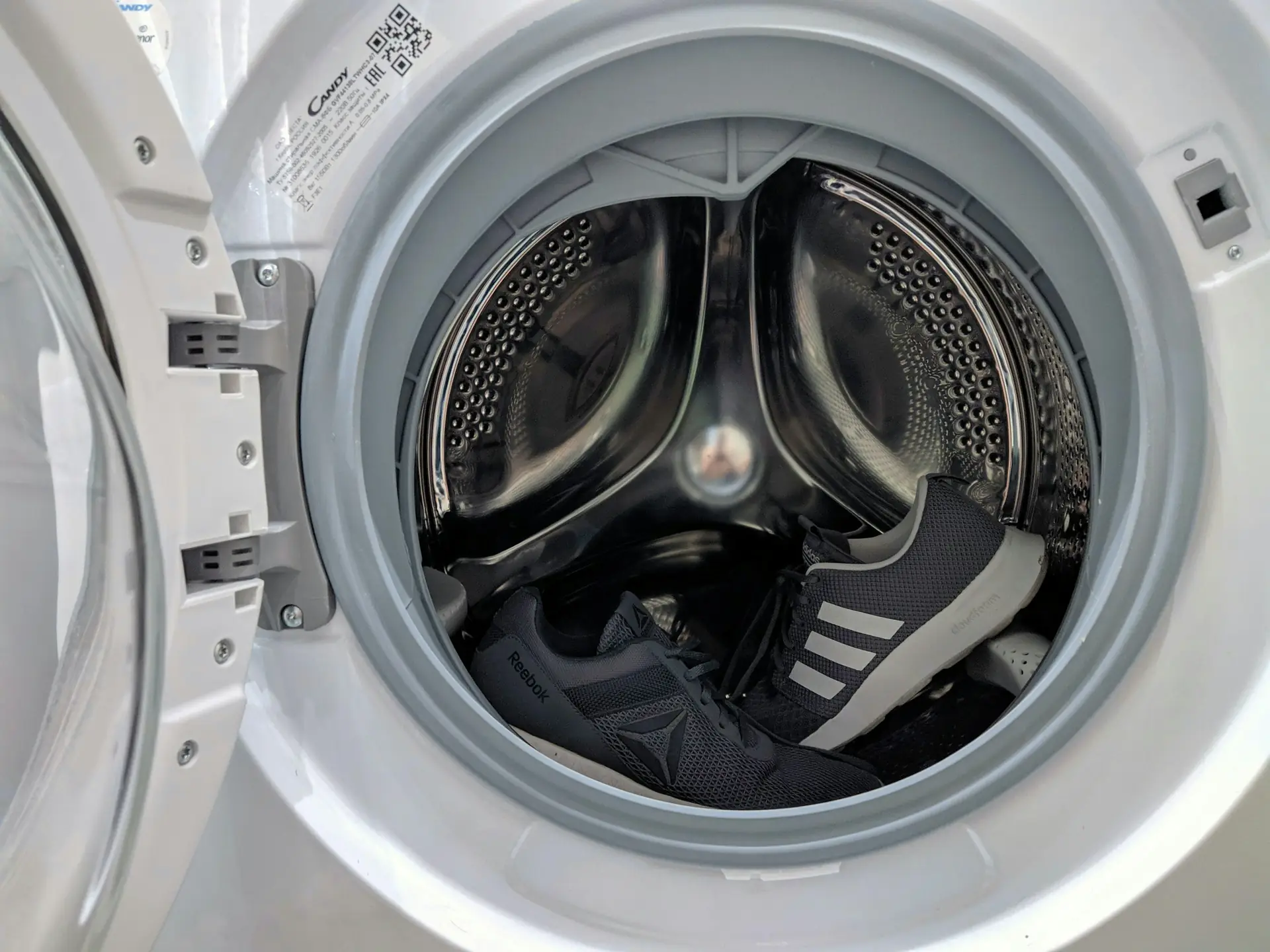 Front-load washing machine with the door open, drum visible
